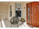 Charming condo balcony with a chair, side table, and decorative door, creating a welcoming outdoor space at 7155 Boca Grove Place Pl # 202, Lakewood Ranch, FL 34202