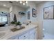 Well-lit bathroom with double sinks, a large mirror, and decorative accents at 7155 Boca Grove Place Pl # 202, Lakewood Ranch, FL 34202