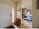Inviting entryway with white door, modern console table, and a glimpse into the stylish living room at 7155 Boca Grove Place Pl # 202, Lakewood Ranch, FL 34202