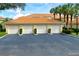Exterior view of condo garages with well-maintained landscaping and tile roofs in a desirable community at 7155 Boca Grove Place Pl # 202, Lakewood Ranch, FL 34202