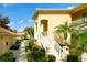 Exterior of condos with stucco walls, tile roofs, palm trees, and landscaped walkways at 7155 Boca Grove Place Pl # 202, Lakewood Ranch, FL 34202