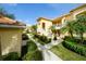Exterior view of condos with well-manicured landscaping, sidewalks, and staircases leading to upper units at 7155 Boca Grove Place Pl # 202, Lakewood Ranch, FL 34202
