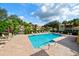 Community pool surrounded by brick pavers, palm trees, and lounge chairs offers a relaxing outdoor space at 7155 Boca Grove Place Pl # 202, Lakewood Ranch, FL 34202