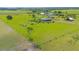 Expansive green property featuring a home, outbuildings, and fenced perimeters at 7745 Wauchula Rd, Myakka City, FL 34251