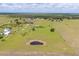 Expansive aerial view of the property showcasing a picturesque pond, lush greenery, and beautiful surroundings at 7745 Wauchula Rd, Myakka City, FL 34251