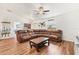 Bright living room with a large brown sectional sofa and unique wood-look floors at 7745 Wauchula Rd, Myakka City, FL 34251