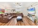 Spacious living room featuring a comfortable sectional sofa, modern ceiling fan, and wood-look floors at 7745 Wauchula Rd, Myakka City, FL 34251