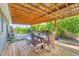 Covered outdoor deck featuring dining table with seating, grill and hammock at 7745 Wauchula Rd, Myakka City, FL 34251
