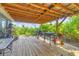 Outdoor grilling and entertaining space on a covered deck with wooden floor at 7745 Wauchula Rd, Myakka City, FL 34251
