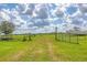 View of the property with an open gate and a boat in the background at 7745 Wauchula Rd, Myakka City, FL 34251