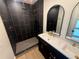 Modern bathroom featuring black tile shower and double vanity with gold fixtures at 808 25Th W Ave, Palmetto, FL 34221