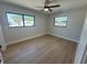 Bright bedroom featuring wood-look tile floors, a modern ceiling fan, and two windows with neighborhood views at 808 25Th W Ave, Palmetto, FL 34221