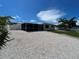 Home featuring an updated exterior, tropical landscaping, and shell driveway at 808 25Th W Ave, Palmetto, FL 34221