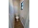 Compact toilet room with wood-look tile flooring, fresh neutral paint, and gold hardware at 808 25Th W Ave, Palmetto, FL 34221