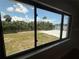 Scenic waterfront view through a window, showcasing a tranquil canal and lush tropical surroundings at 808 25Th W Ave, Palmetto, FL 34221
