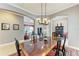 Formal dining room features decorative columns, a large table with seating for six, and elegant lighting at 8206 Heritage Grand Pl, Bradenton, FL 34212