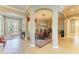 An open dining room with decorative columns, arched ceilings, and elegant furnishings next to the foyer at 8206 Heritage Grand Pl, Bradenton, FL 34212