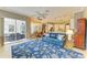 Open living space with a blue sofa, rug with floral pattern, and a view into the kitchen at 8206 Heritage Grand Pl, Bradenton, FL 34212