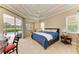 Large main bedroom with sliding glass doors, tray ceiling, and views of the pool and golf course at 8206 Heritage Grand Pl, Bradenton, FL 34212