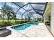 Screened pool and spa overlooking golf course with beautiful landscaping and tiled patio at 8206 Heritage Grand Pl, Bradenton, FL 34212