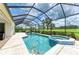 Screened-in pool with a spa and tiled patio, overlooking lush landscaping and a pristine golf course at 8206 Heritage Grand Pl, Bradenton, FL 34212