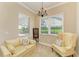 Cozy sitting room with golf course views, a sofa, an armchair, and a decorative chandelier at 8206 Heritage Grand Pl, Bradenton, FL 34212