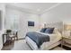 Clean bedroom features a bed with blue patterned throw and gray upholstered chair at 8312 Catamaran Cir, Lakewood Ranch, FL 34202