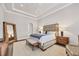 Comfortable bedroom featuring tray ceiling, hardwood floors, and neutral decor at 8312 Catamaran Cir, Lakewood Ranch, FL 34202