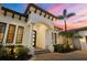 Close up of the home's entrance featuring an arched entryway, pillars, and a professionally landscaped yard at 8312 Catamaran Cir, Lakewood Ranch, FL 34202