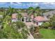 Elegant Mediterranean-style home with a well-manicured lawn, palm trees, paver driveway, and a three-car garage at 8312 Catamaran Cir, Lakewood Ranch, FL 34202