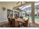 An outdoor patio with a wooden dining table, wicker chairs, and a view of the pool at 8312 Catamaran Cir, Lakewood Ranch, FL 34202