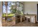 Outdoor kitchen with stone backsplash, stone countertop, and stainless steel appliances at 8312 Catamaran Cir, Lakewood Ranch, FL 34202