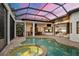 A screened-in pool and spa area with an outdoor kitchen and dining space, perfect for entertaining at 8312 Catamaran Cir, Lakewood Ranch, FL 34202