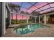 Screened-in pool with hot tub, and views of lush tropical landscaping at 8312 Catamaran Cir, Lakewood Ranch, FL 34202