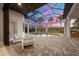 A screened-in pool area with a hot tub, comfortable seating, and a beautiful view of the surrounding landscape at 8312 Catamaran Cir, Lakewood Ranch, FL 34202