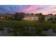 Beautiful home exterior with palm trees, and a serene pond view reflecting the stunning sunset hues in the sky at 8312 Catamaran Cir, Lakewood Ranch, FL 34202