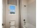 Bathroom with a toilet, bathtub with white tiles, and a neutral-patterned shower curtain at 8583 Big Dipper Dr, Sarasota, FL 34241