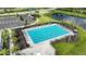 A rectangular pool with marked lanes, surrounded by palm trees, lounge chairs, and lush landscaping at 8583 Big Dipper Dr, Sarasota, FL 34241