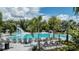 Resort-style pool with a water slide, lounge chairs, umbrellas, and lush tropical landscaping at 8583 Big Dipper Dr, Sarasota, FL 34241