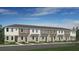 New townhome building with neutral siding, a dark roof, and well-manicured front lawns on a sunny day at 8592 Daybreak St, Sarasota, FL 34241