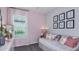 Pink bedroom with plush daybed, decorative pillows, and whimsical art prints at 8632 Snowfall St, Sarasota, FL 34241