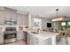 Bright, modern kitchen with stainless steel appliances, light gray cabinetry, and a large island at 8632 Snowfall St, Sarasota, FL 34241
