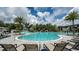 Large community pool with a splash pad and lounge chairs surrounded by palm trees and lush landscaping at 8632 Snowfall St, Sarasota, FL 34241