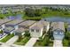 Aerial view of a home with a pond in the background, surrounded by lush trees and other homes in the community at 9148 Royal River Cir, Parrish, FL 34219