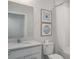 Bright bathroom with white vanity, tub, and coastal-themed wall art at 9148 Royal River Cir, Parrish, FL 34219