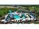Aerial view of community pool and splashpad with several separate lounge areas and mature landscaping throughout at 9148 Royal River Cir, Parrish, FL 34219