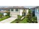 Two-story home boasts a front-facing two-car garage, a light beige exterior, and is complimented with lush landscaping at 9148 Royal River Cir, Parrish, FL 34219