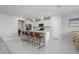 Bright, open kitchen featuring a white quartz island with bar stool seating, stainless appliances, and bright white cabinets at 9148 Royal River Cir, Parrish, FL 34219