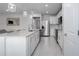 Bright, open kitchen featuring a white quartz island with bar stool seating, stainless appliances, and bright white cabinets at 9148 Royal River Cir, Parrish, FL 34219