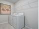 Laundry room with appliances, tiled flooring, and wall decor at 9148 Royal River Cir, Parrish, FL 34219
